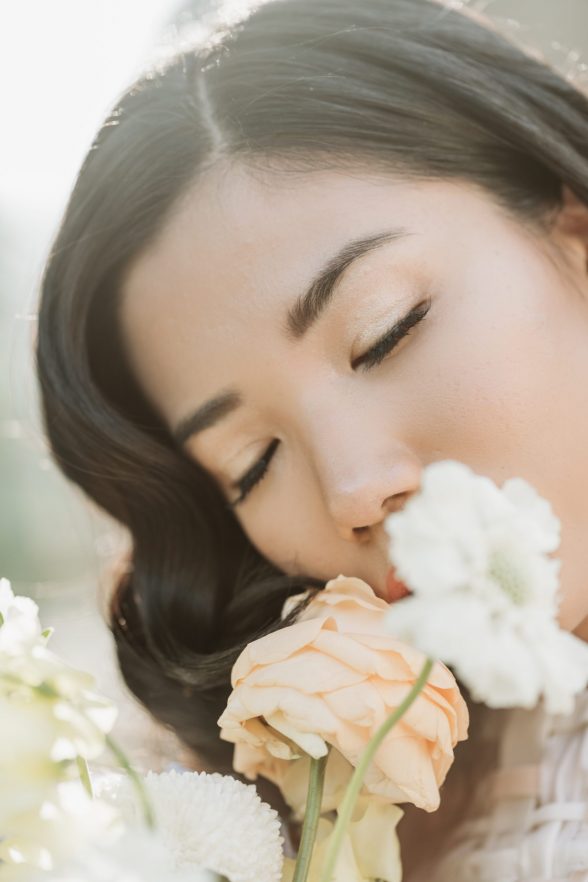 Asian bride smelling flowers